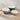 Three stoneware mixing bowls with embossed sides and smooth interiors, shown on a beige counter top against a tiled wall. The bowls are in teal, pale pink, and light blue, with cream-colored interiors and have a spoon rest in the edge.
