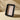 A black rectangular picture frame with rounded corners and a light beige insert card printed with the 'salt&pepper' logo, shown on a beige background with strong shadows.