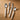 A cutlery set including fork, knife, spoon and teaspoon with white handles photographed on a wooden tabletop.