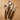 A cutlery set including fork, knife, spoon and teaspoon with wooden look handles photographed on a wooden benchtop.
