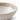 A close up of a bowl with a striped edge on the inside rim, photographed on a clean white background.