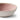 A close up of a small beige dip bowl with pink interior photographed on a white background.