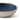 A close up of a small beige dip bowl with dark blue interior photographed on a white background.