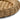 A closeup of the raised rim of a round woven natural tray, shown on a clean white background.