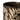 A closeup of the top edge of a stoneware mug in a dark brown colour, decorated with a cream wax resist leaf pattern, photographed on a clean white background.