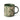 A stoneware mugs in a deep green colour, decorated with a cream wax resist leaf pattern, photographed on a clean white background.